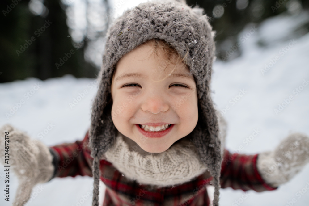Portrait of small girl enjoying winter holiday in the mountains with family, playing in snow.