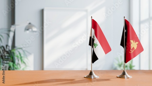 FLAGS OF IRAQ AND PAPUA NEW GUINEA ON TABLE photo