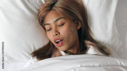 Asian woman with colored hair sleeping and snoring