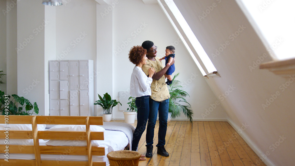 Loving Parents Holding Newborn Baby Son At Home In Bedroom Of Loft Apartment Loving Parents Holding Newborn Baby Son At Home In Bedroom Of Loft Apartment