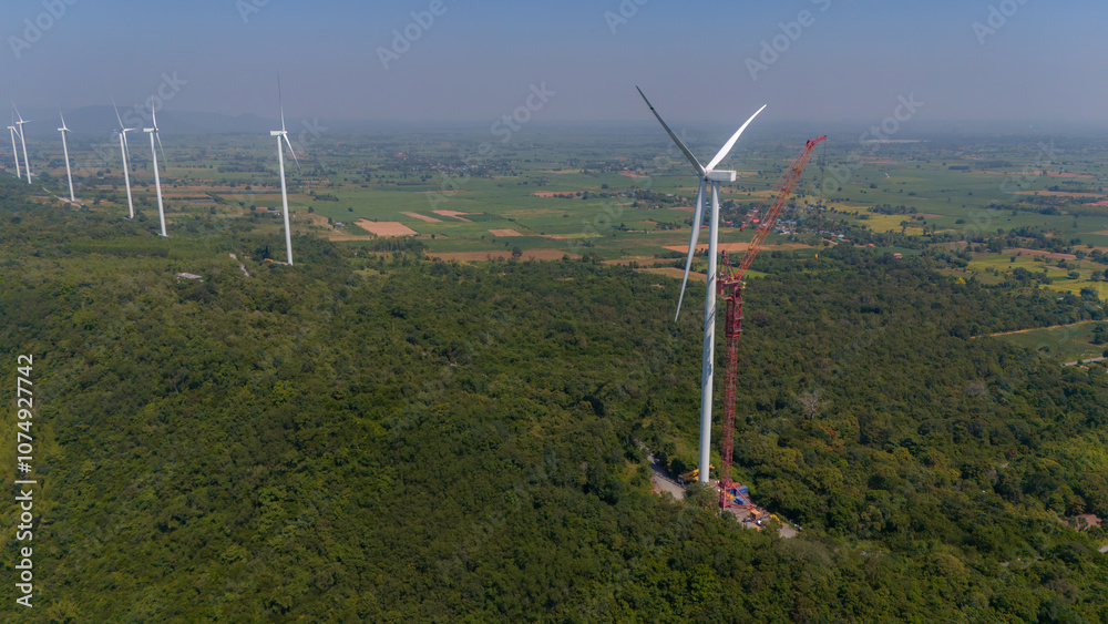 Wind turbine being repaired. Engineers are checking turbine wing on top of a Hight Crane at Wind turbine Power. Crane taking down the blades of an old wind turbine Wind turbine being repaired. Engineers are checking turbine wing on top of a Hight Crane at Wind turbine Power. Crane taking down the blades of an old wind turbine
