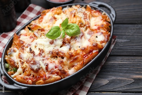 Delicious al forno pasta in baking dish on wooden table, closeup