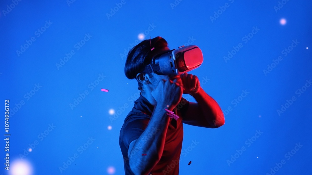 Skilled gamer boxing and punching floating box while wearing VR glasses to connect metaverse. Male model using virtual reality goggles while exercising and standing at neon background. Apparatus. Skilled gamer boxing and punching floating box while wearing VR glasses to connect metaverse. Male model using virtual reality goggles while exercising and standing at neon background. Apparatus.