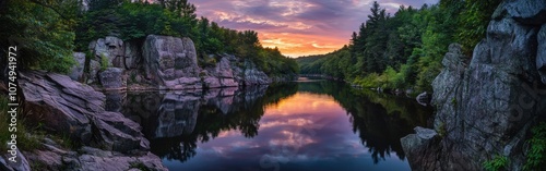 A tranquil evening panorama of still waters reflecting vibrant sunset colors in a serene forested landscape