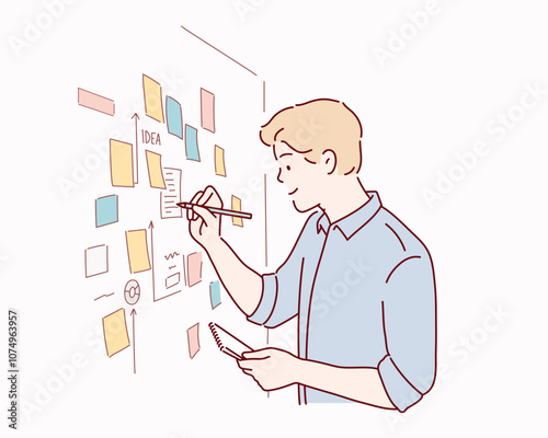  male employee write on colorful sticky notes develop business project in office, concentrated biracial man worker brainstorm engaged in creative thinking make startup plan.