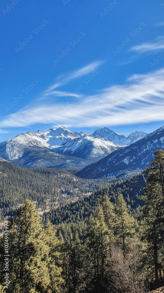 Majestic snow-capped mountains rise under a clear blue sky, surrounded by lush green forests and distant peaks at sunrise Majestic snow-capped mountains rise under a clear blue sky, surrounded by lush green forests and distant peaks at sunrise