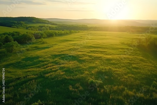 Drone shot of a vast, open grassland at sunrise.