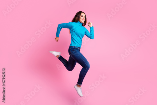 Carefree woman jumping against pastel background