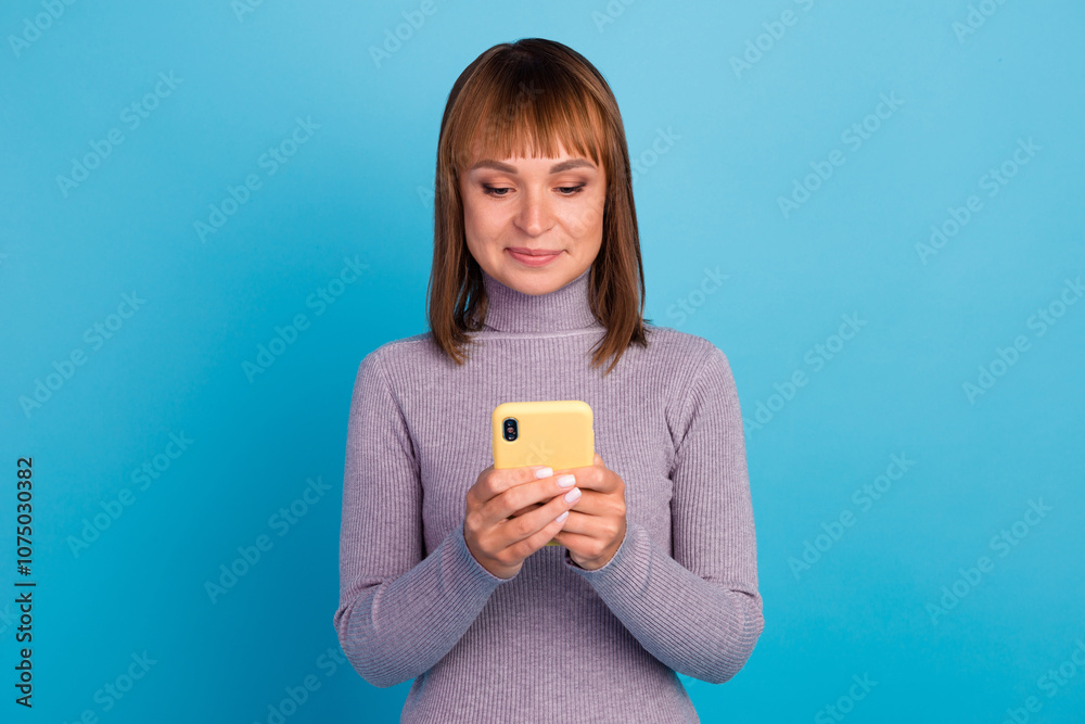 Smiling young brunette woman girl in sweater posing isolated on pastel background studio portait. People lifestyle concept. Mock up copy space. Using mobile phone, typing sms message Smiling young brunette woman girl in sweater posing isolated on pastel background studio portait. People lifestyle concept. Mock up copy space. Using mobile phone, typing sms message
