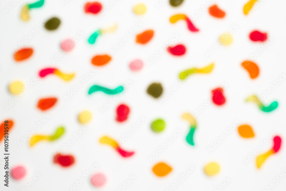 Blurred colorful gummy candies on isolated white background