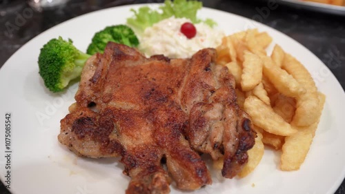 Grilled chicken chop with salad, broccoli and french fries.