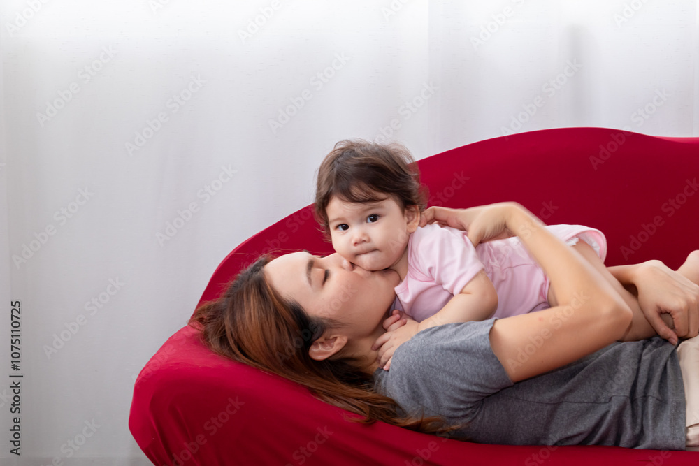 Asian woman spend holiday time at home with toddler infant having fun playing, hugging with love care bonding relationship, happy young mother holding baby daughter talking and laughing together Asian woman spend holiday time at home with toddler infant having fun playing, hugging with love care bonding relationship, happy young mother holding baby daughter talking and laughing together