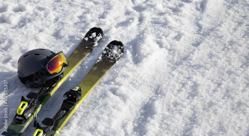 Mountain skis, ski helmer with sunscreen mask / ski goggles on bright alpine snow. Winter holidays. Extreme sport. Vacation, travel content. Copy space