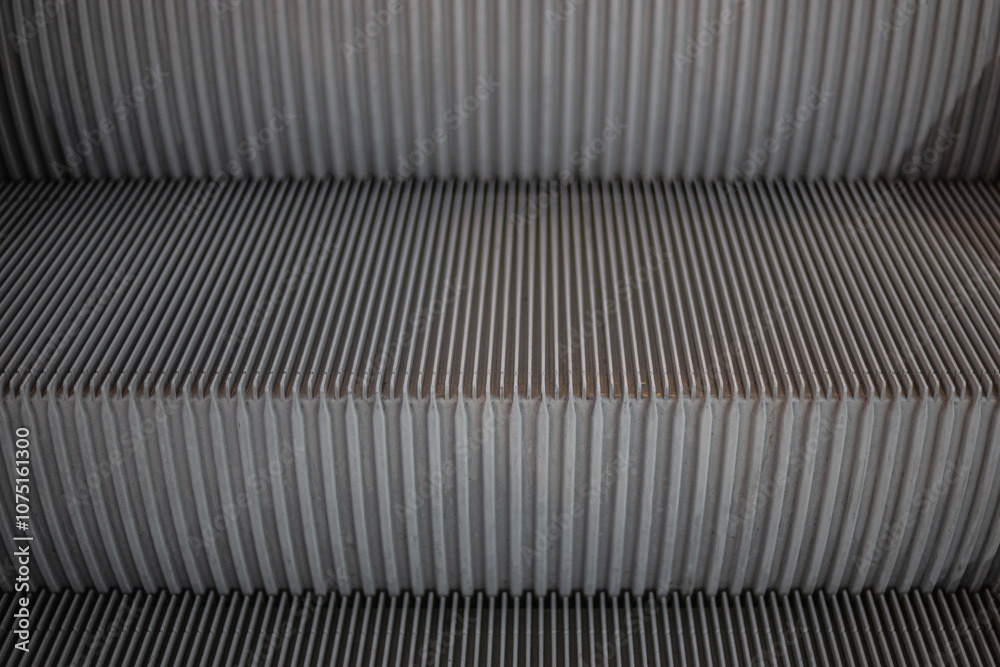 Close-up escalators in neutral tones, highlighting symmetrical design and textured steps. Modern urban transportation infrastructure detail, material background Close-up escalators in neutral tones, highlighting symmetrical design and textured steps. Modern urban transportation infrastructure detail, material background