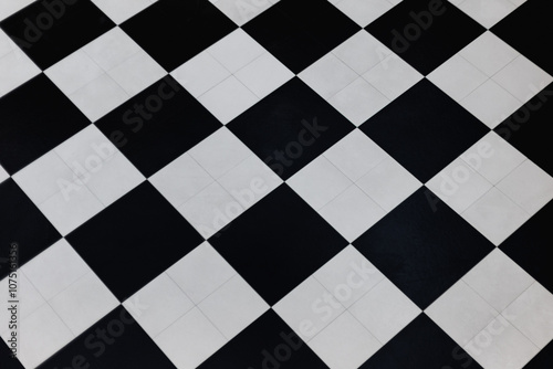 Classic black and white checkered floor tiles in diagonal pattern. Abstract geometric design creating a timeless contrast in modern interior flooring.