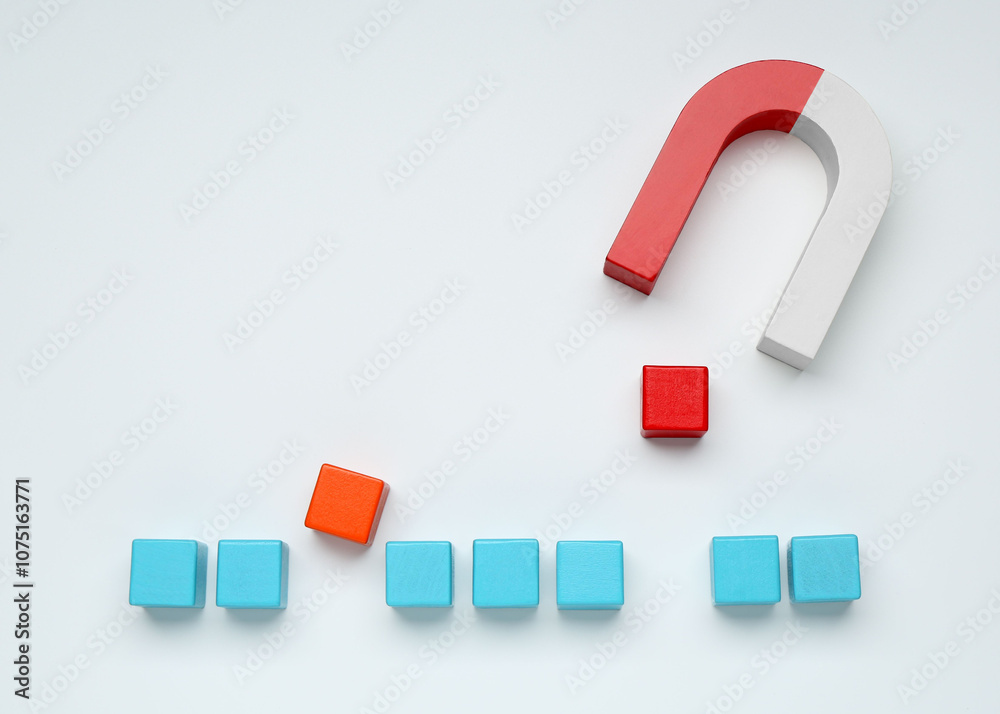 Magnet attracting colorful cubes on white background, flat lay Magnet attracting colorful cubes on white background, flat lay