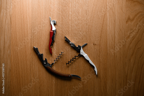 Three different corkscrews for opening corked wine are chaotically photo