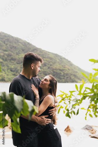 Caucasian couple hugginh in front of the sea, closing eyes, feeling the moment. photo