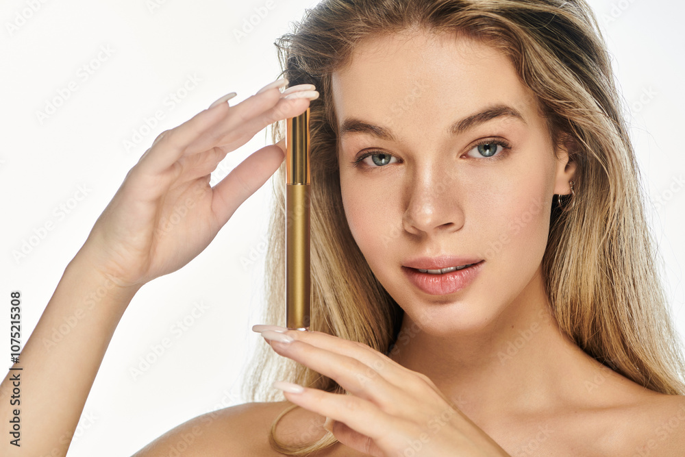 Fototapeta premium A smiling young woman showcases her skincare routine with a golden serum.
