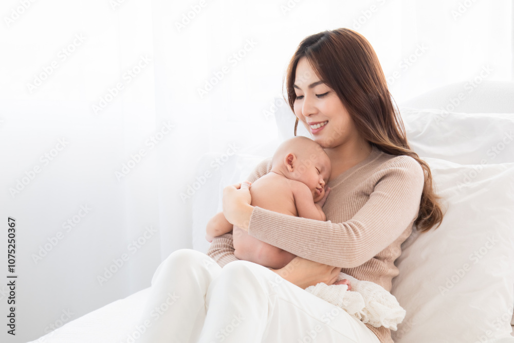 Asian loving mother caring for her newborn baby at home, sleeping baby in her arm with love and care, adorable cuddle sleep on chest mom and safe, healthcare infant and mother nurturing concept Asian loving mother caring for her newborn baby at home, sleeping baby in her arm with love and care, adorable cuddle sleep on chest mom and safe, healthcare infant and mother nurturing concept