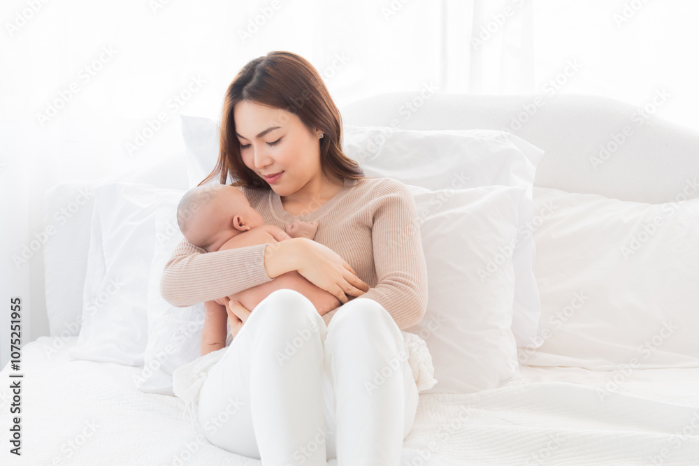 Young cheerful and beautiful Asian mom sleeping baby in arm, mother and newborn bonding relationship. Mother holding adorable healthcare nurturing. woman tenderly cuddles infant with love and care Young cheerful and beautiful Asian mom sleeping baby in arm, mother and newborn bonding relationship. Mother holding adorable healthcare nurturing. woman tenderly cuddles infant with love and care