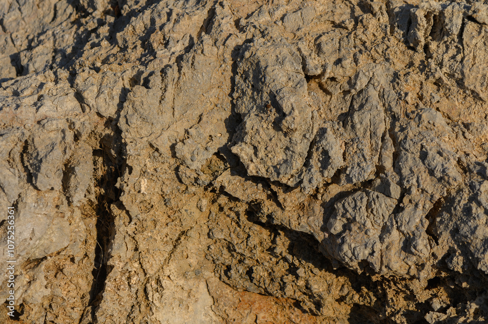 Textures of weathered rock formation illuminated by warm sunlight at the edge of a rugged landscape. Textures of weathered rock formation illuminated by warm sunlight at the edge of a rugged landscape.