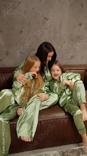 Mother and daughter laughing together in matching pajamas. Concept of family entertainment. photo