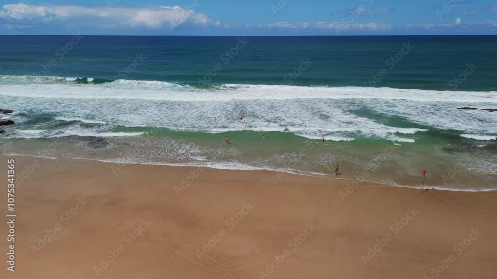 Drone flies up and pans down over beach with swimmers, white waves, and blue ocean in Itacare, Bahia, Brazil Drone flies up and pans down over beach with swimmers, white waves, and blue ocean in Itacare, Bahia, Brazil