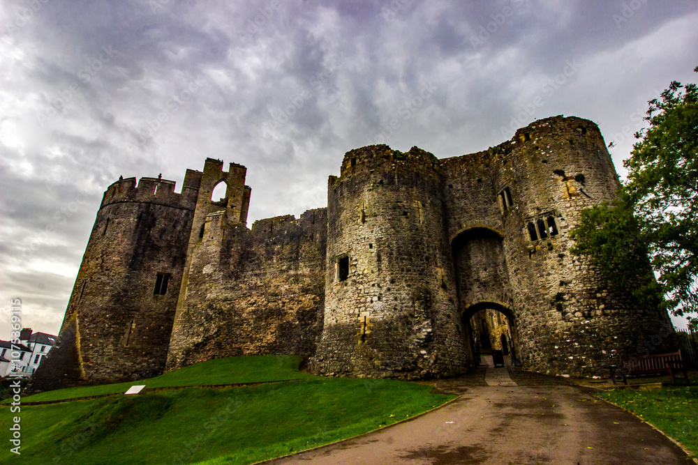 The twin tower gatehouse of Chepstow Castle in Wales, with light trying to break through a thin cloud cover. The twin tower gatehouse of Chepstow Castle in Wales, with light trying to break through a thin cloud cover.