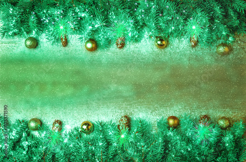 Christmas background with fir branches and Christmas tree decorations on a green wood texture. New Year background and frame for design banners and cards.