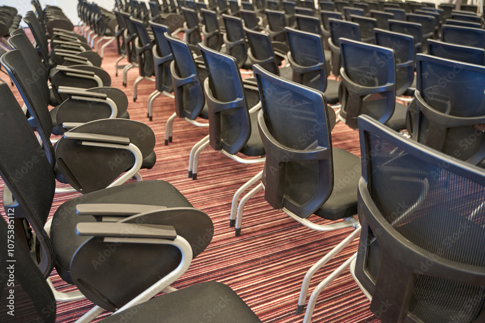 Fototapeta premium Rows of empty conference chairs on patterned carpet in modern meeting room.