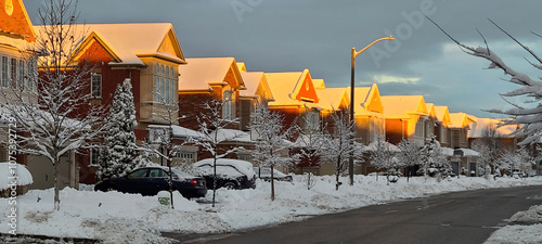 Billede på lærred Morning sun shining on the snow-covered roofs