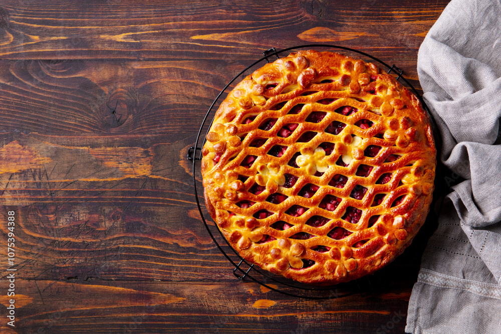 Berry fruit cake on cooling rack. Brown background. Copy space. Top view. Berry fruit cake on cooling rack. Brown background. Copy space. Top view.
