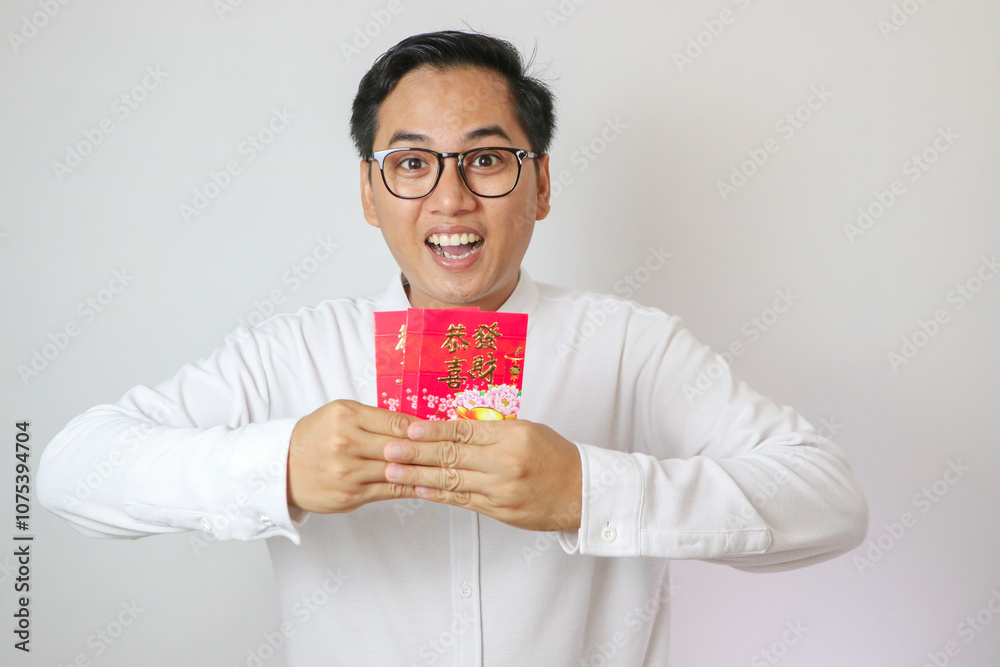 Happy Chinese new year. Asian man holding angpao or red packet monetary gift isolated on white background. Chinese text means great luck great happy Happy Chinese new year. Asian man holding angpao or red packet monetary gift isolated on white background. Chinese text means great luck great happy