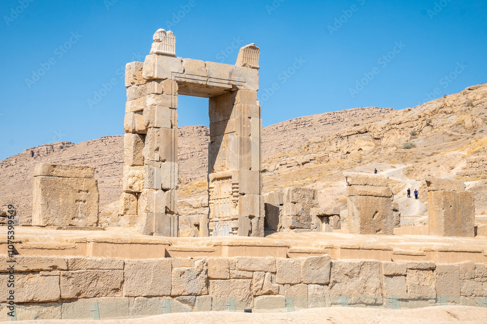 Persepolis, beautiful stone archway stands tall with a blue sky, Iran Persepolis, beautiful stone archway stands tall with a blue sky, Iran