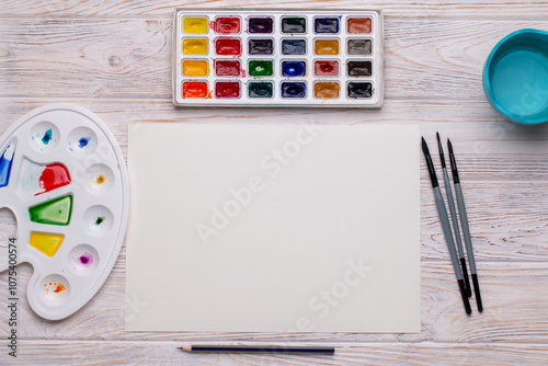 Top View of Blank Canvas with Art Supplies on White Wooden Table