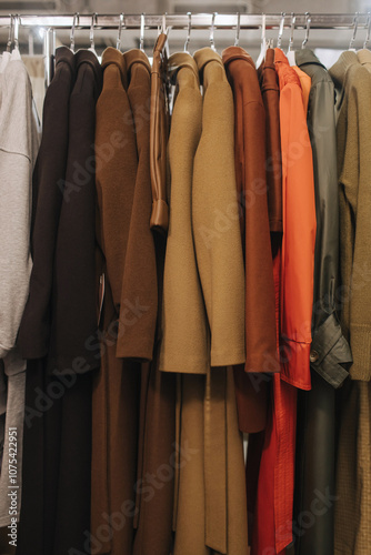 Choice of fashion clothes of different colors on hangers in a retail shop. Reduce Reuse Recycle concept