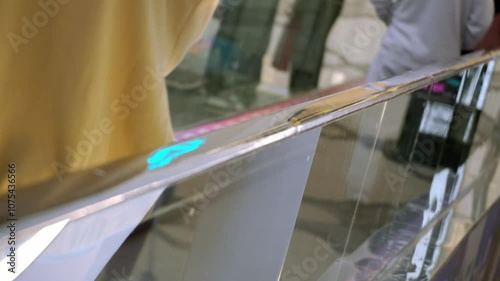 Selective focus close up shot of people hands on moving walkway or sidewalk handrail at airport or shopping mall. Passengers walking on horizontal escalator concept. photo