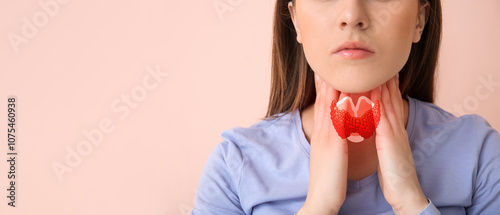 Young woman checking thyroid gland on color background, closeup