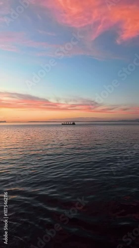 Vertical view of sailing ship during ocean sea sunset with cargo boats, 4k reel