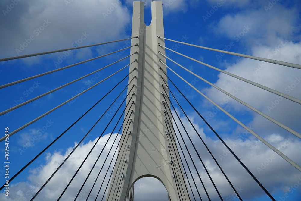 Naklejka premium New suspension bridge of the Arade river (Rio Arade), Portimao, Algarve, Portugal. Geometry of the white suspension cables for the N125 federal highway against the blue sky.