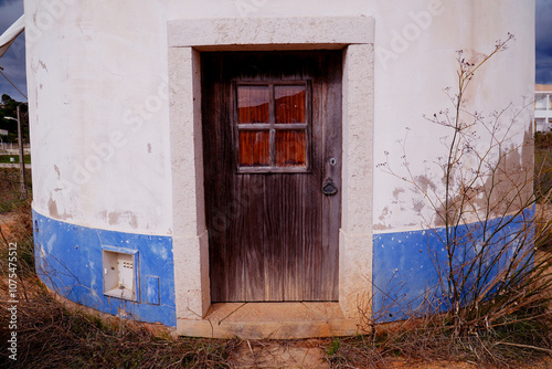 Traditional old Portuguese windmill at the N125 national road near the village Budens, Algarve, Portugal. Entrance door of the no longer used windmill. photo