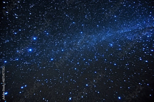 Dazzling blue specks scattered across a velvety black surface, twinkling specks, radiant fragments photo