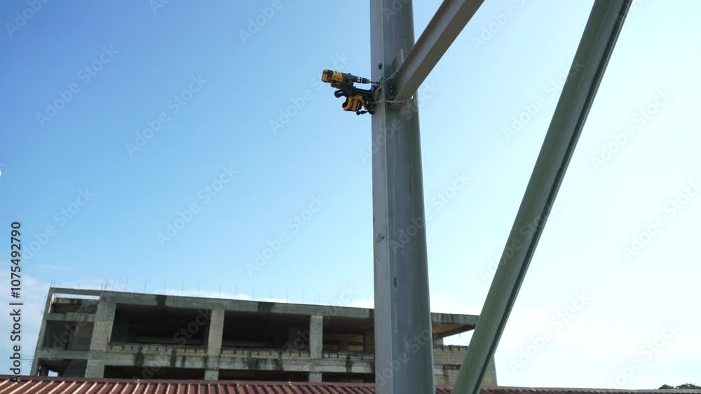 Magnetic drill mounted on a steel beam. For safety, it is securely attached to the beam with a magnet and a metal chain. This is a portable drill with a magnetic base. Magnetic drill mounted on a steel beam. For safety, it is securely attached to the beam with a magnet and a metal chain. This is a portable drill with a magnetic base.