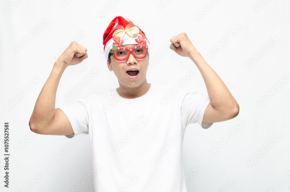 Naklejka premium happily attractive young asian man wearing santa claus hat and christmas glasses dancing and celebrating christmas. christmas and holiday concept.