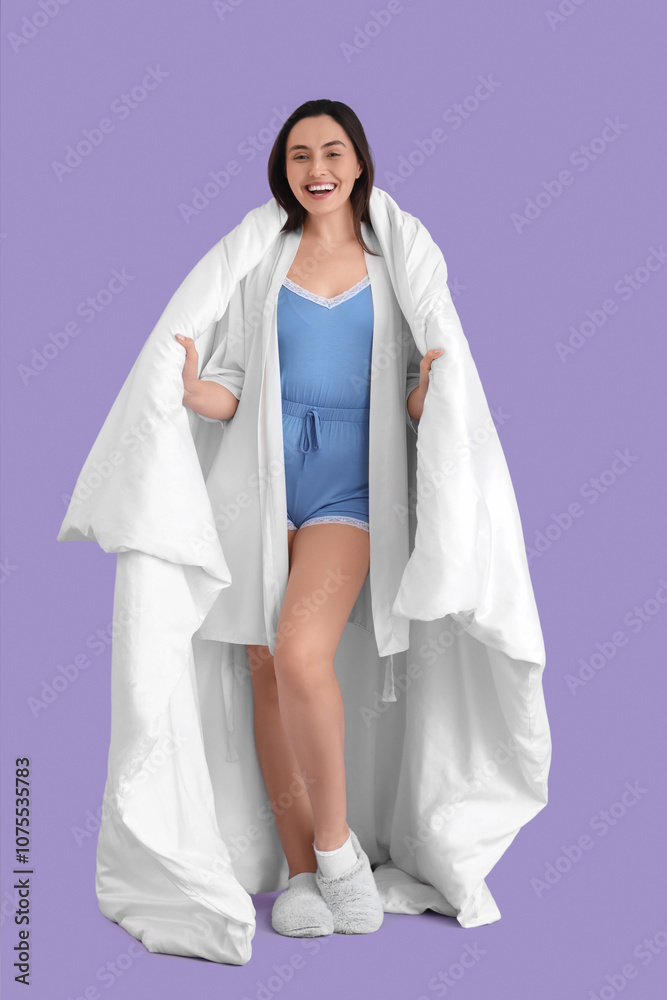 Young woman in pajamas with soft blanket on lilac background Young woman in pajamas with soft blanket on lilac background