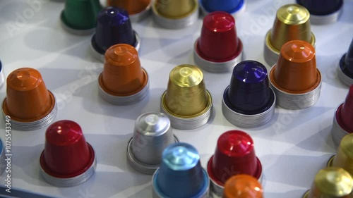 Close-up view of group of various multi coloured empty aluminium packages for coffee capsules (or coffee pods) lying on grey table. Coffee tool background. Copy space. Recyclable material theme.