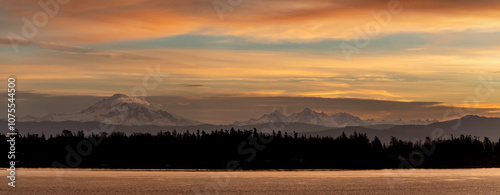 Mt. Baker during a colorful and dramatic sunrise looking across Hale Passage in the Salish Sea area of western Washington state. Seen from Lummi Islands east side during the minutes before sunrise.
