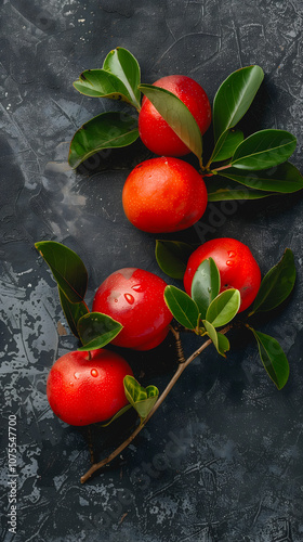 Fresh acerola with droplets of water on dark surface. photo