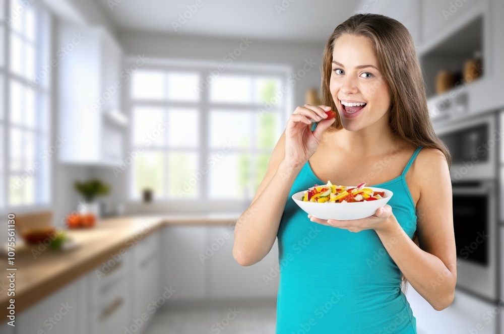 Happy beautiful woman eat healthy fruit in the kitchen Happy beautiful woman eat healthy fruit in the kitchen